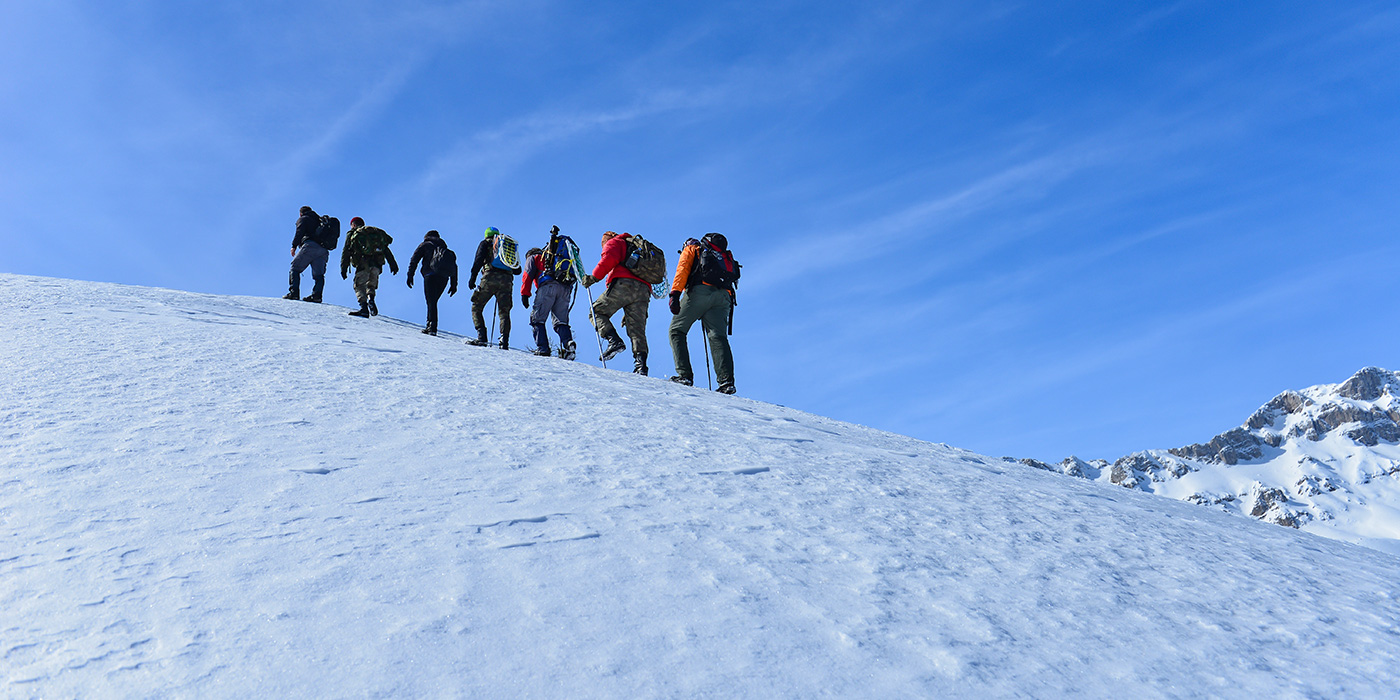 Team Climbing a Snow-Covered Mountain Together