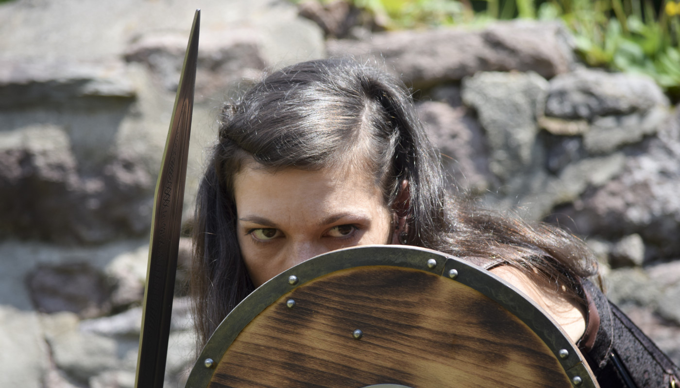 Female warrior, defensively holding her shield.